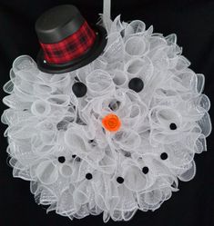 a close up of a snowman wreath with a top hat on it's head