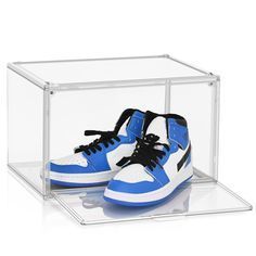 a pair of blue and white sneakers in a clear box with black laces on the top