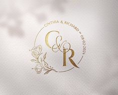 a close up of a white and gold logo on a piece of paper with the letter c and r