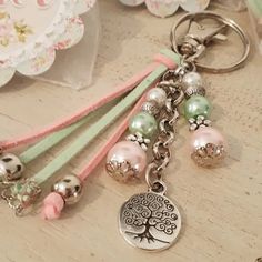 a keychain that has some beads on it and a tree charm attached to it