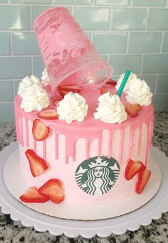 a pink starbucks cake with strawberries and whipped cream