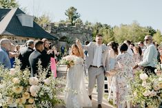 a bride and groom walking down the aisle