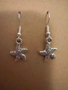 Silver starfish earrings on silver hypoallergenic nickel free fishhook earrings Casual Star Jewelry For Summer, Casual Star-shaped Summer Jewelry, Casual Summer Star Shaped Jewelry, Summer Starfish Charm Drop Earrings, Sterling Silver Starfish Charm Dangle Earrings, Silver Star Earrings For Summer, Nickel-free Starfish Earrings As Gift, Nickel-free Starfish Earrings For Gifts, Starfish-shaped Nickel-free Earrings For Gifts