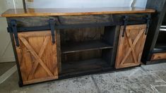 an entertainment center made out of wood and metal with sliding doors on the front door