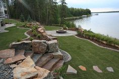 an outdoor patio area with steps leading to the water's edge and landscaping around it