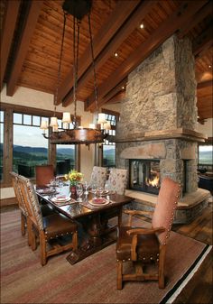 a dining room table with chairs and a fire place in the middle of the room