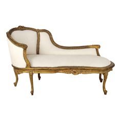 an antique style chaise lounge chair with white upholstered fabric and gold trim