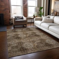 a living room filled with furniture and a large rug on top of a hard wood floor