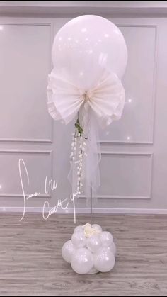 white balloons and flowers are arranged on the floor