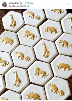 some gold foiled animals on white hexagons with wooden table in background