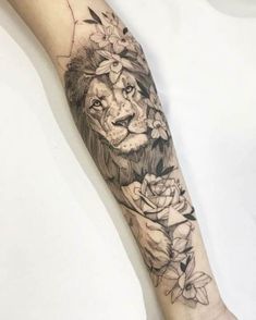 a lion with flowers on his head and neck is shown in this forearm tattoo design