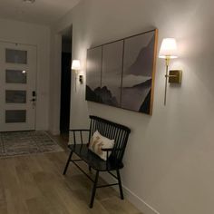 a black chair sitting on top of a hard wood floor next to a white door