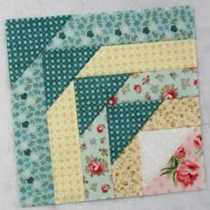 a close up of a patchwork quilt with flowers on the top and bottom half