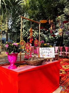 a red table topped with lots of vases filled with flowers