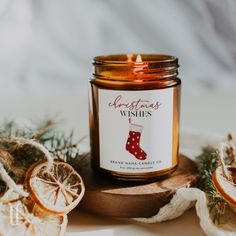 a candle that is sitting next to some oranges and other fruit on a table