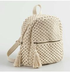 a white backpack with tassels on it