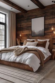 a large bed sitting next to a window in a room with wooden walls and flooring