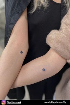 a woman's arm with two small dots on the left side of her arm