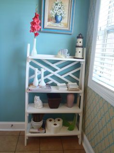 a shelf with toilet paper and other items on it in a room that has blue walls