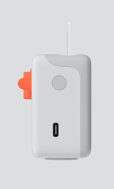 an orange object is attached to a white wall mounted light switch on a gray background