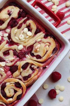 raspberry rolls in a white baking dish with almonds