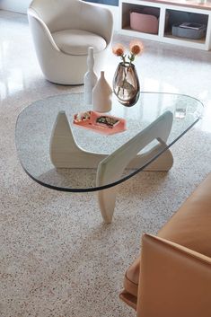 a living room with a glass table and white chairs