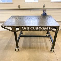 a metal workbench sitting in front of a garage door with the word avr custom printed on it