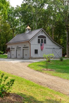 a large gray barn with an american flag on it