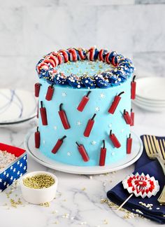 a blue cake with red, white and blue decorations on it sitting on a table