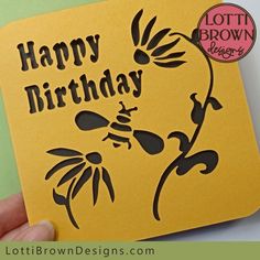 a person holding up a yellow birthday card