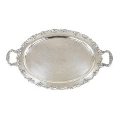 an ornate silver tray with handles and beading on the rim, set against a white background