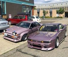 two purple cars parked next to each other in front of a building