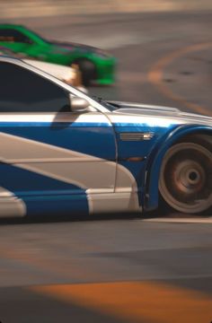 a blue and white car driving down a street