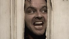 a man with his mouth open peeking out from behind a door