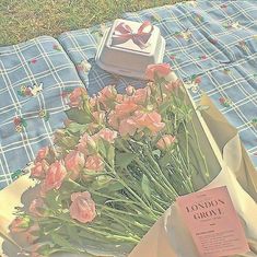 a bunch of pink flowers sitting on top of a table next to a box with a bow