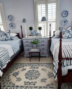 two beds in a bedroom with blue and white decor