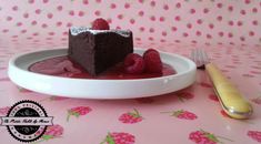 a piece of chocolate cake on a plate with raspberries