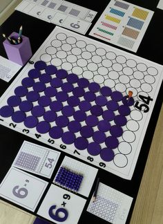 a table topped with lots of purple and white pieces of paper on top of it