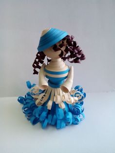 a paper doll wearing a blue dress and hat with flowers in it's hair