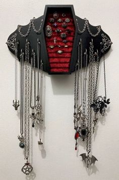 a wall mounted clock with many necklaces hanging from it's sides