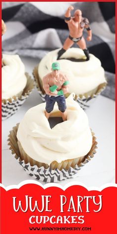 some cupcakes with white frosting and two figurines on top