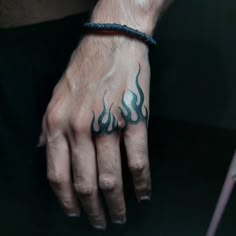 a man's hand with flames tattooed on it