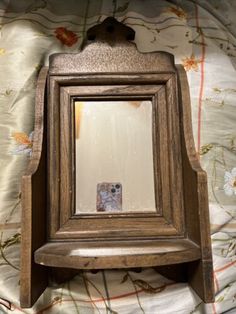 an old wooden mirror sitting on top of a bed