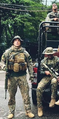 three soldiers are sitting in the back of a truck