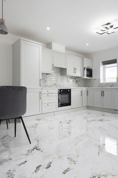 a kitchen with marble floors and white cabinets