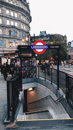 an underground subway station with people walking on the sidewalk and in the distance, there is a sign that says underground