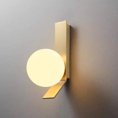 a light that is on the wall next to a gray wall with a white ball