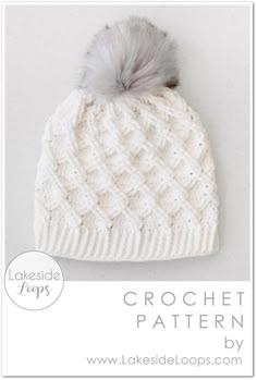 a white knitted hat with a gray pom - pom