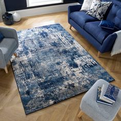 a living room area with blue couches, chairs and a rug on the floor