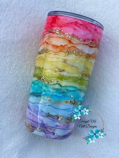 a rainbow colored tumble cup with glitter on it